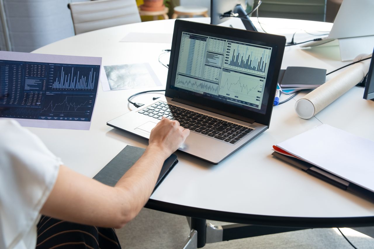 services-img Business person evaluating financial charts on a laptop in a modern office setting.