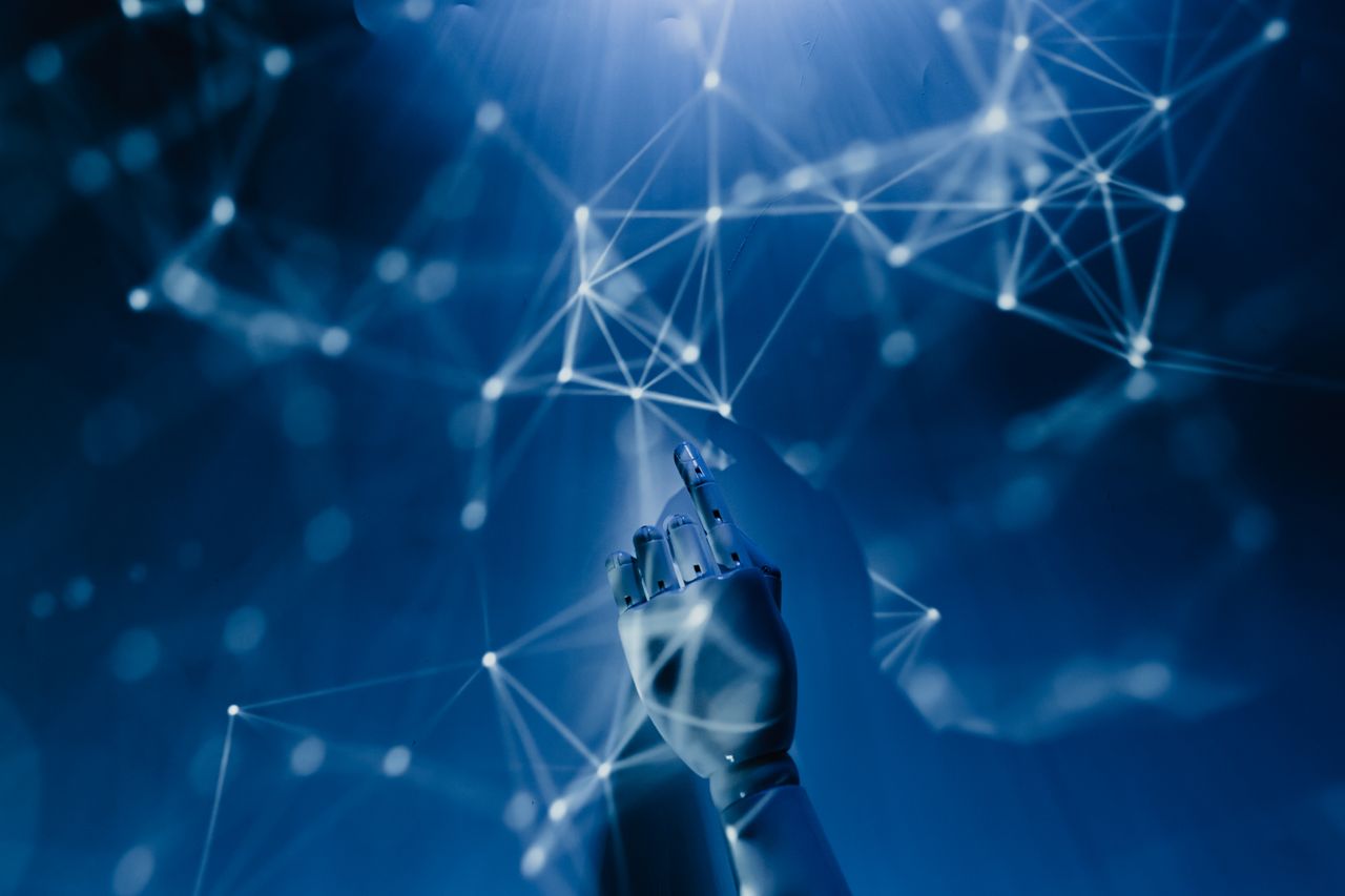 our-experience A robotic hand reaching into a digital network on a blue background, symbolizing AI technology.