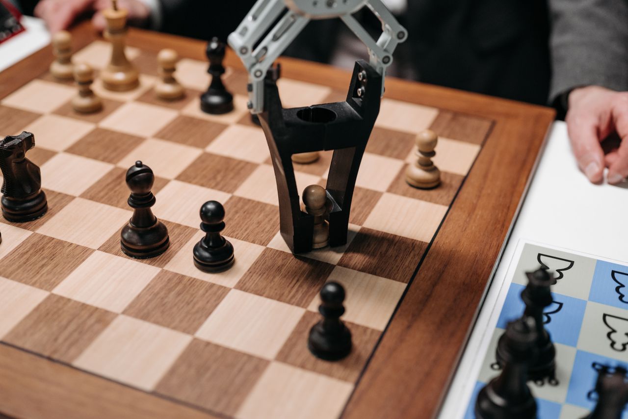 about-02 Robotic arm playing a strategic chess game on a wooden board, showcasing technology and innovation.